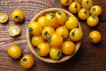 Many fresh yellow tomatoes on wooden table, flat lay