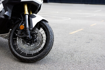 Front Wheel and Suspension of Adventure Motorcycle on Asphalt Road