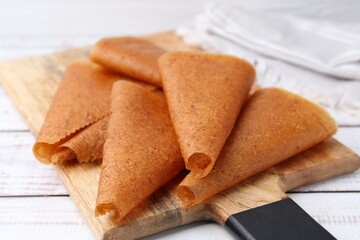 Delicious fruit leather rolls on white wooden table, closeup
