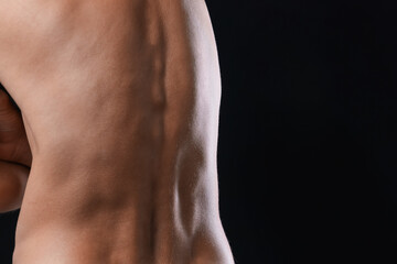 Man suffering from anorexia on black background, closeup. Space for text