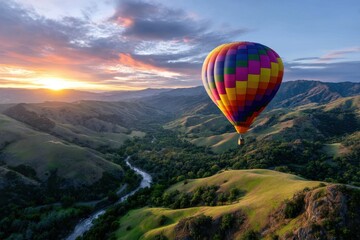 Colorful hot air balloon glides over valleys during sunrise in scenic landscape