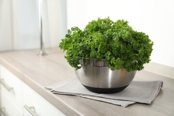 Fresh parsley in bowl on table indoors. Space for text