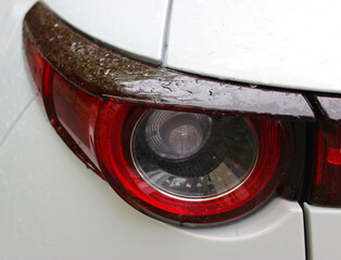 Water drops on a car rear light after heavy rain close up photo
