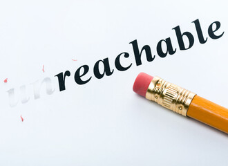 Word " unreachable " and pencil with eraser close-up