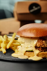 Delicious crispy chicken burger dripping with cheese sauce and french fries