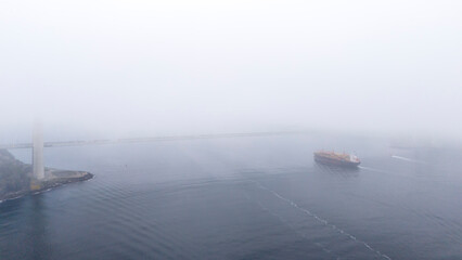 Misty Seascape with Ships and Coastal Structures. A serene, slightly overcast seascape showcasing a...