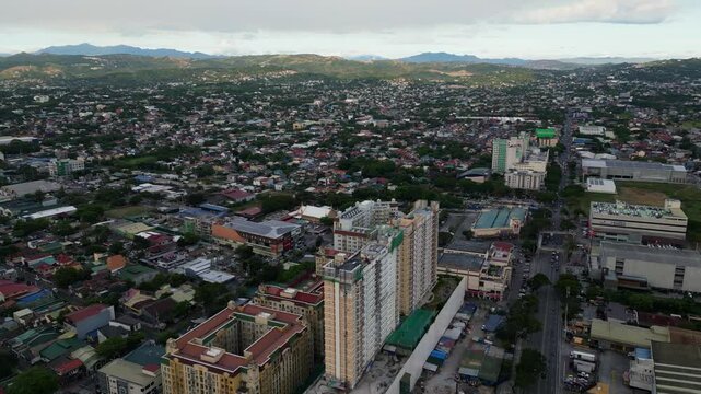 Orbiting aerial view of apartment building under construction at Marikina cityscape during daytime - NCR, Luzon, Philippines