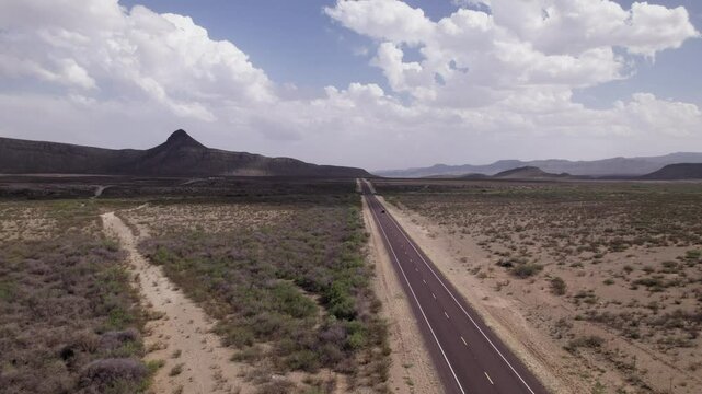 Aerial view of an SUV driving through the desert on an empty highway in West Texas