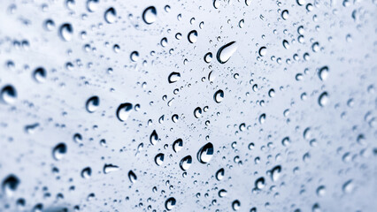 Raindrops on Glass: A close-up shot reveals individual raindrops delicately clinging to a pane of glass, creating a captivating and serene display of nature's artistry.