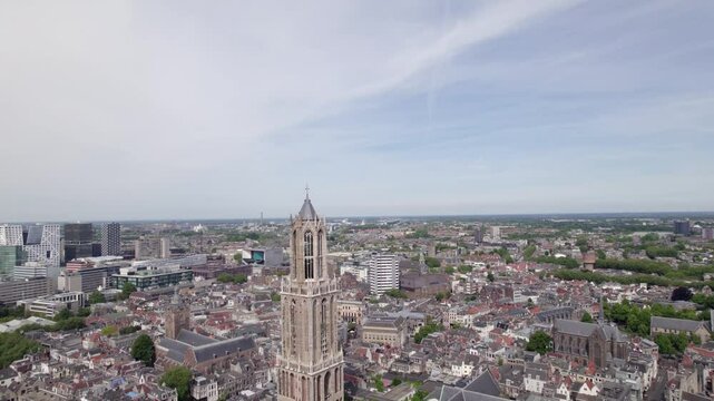 Descending aerial reveal cathedral nave of De Dom church tower and the gothic architecture of the Utrecht diocese ambulatory and transept. Holland religious tourist destination seen from above.