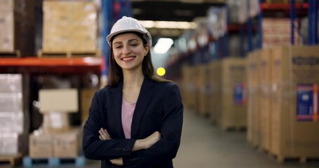 Asian female manager smiles confidently giving double thumbs up inside warehouse showing satisfaction and encouragement during slowmotion positive moment in successful teamwork environment - Powered by Adobe