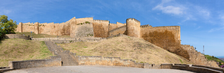 Fototapeta premium Panorama of the defensive wall of the ancient fortress of Naryn-Kala on a sunny May day. Derbent, Dagestan. Russian Federation
