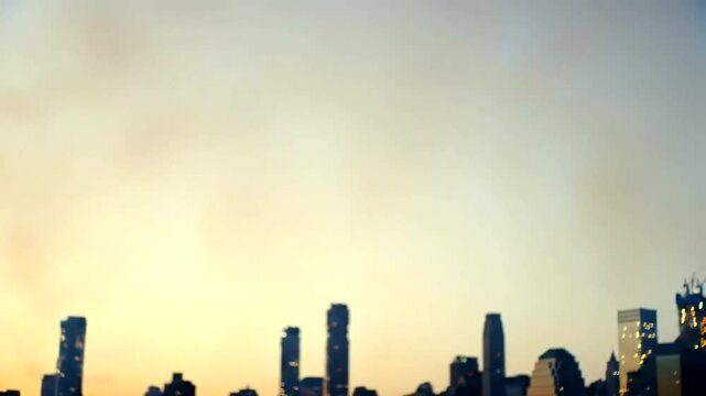 City Skyline Silhouette Against Warm Sunset Sky Defocused