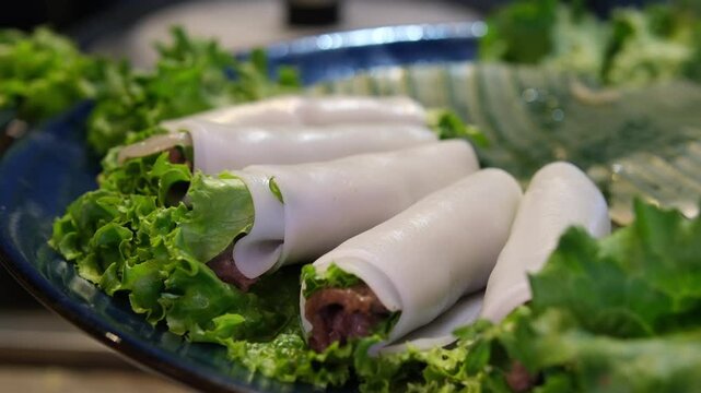 Vietnamese spring rolls with prawns in rice paper in blacl platter isolated on white background. Asian cuisine. High quality 