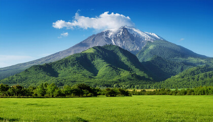 majestic mountain towering over lush green fields under a bright blue sky