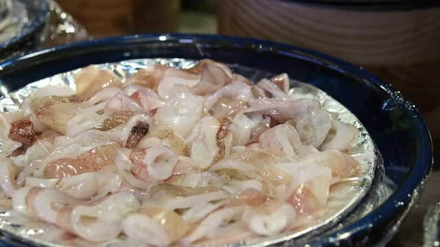 pieces of raw squid, close-up, on a plate. Sliced raw squid