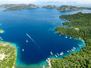 Sailing boats navigating the turquoise waters of Sarsala Bay in Dalaman, Turkey