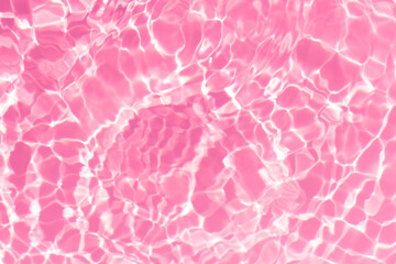 Fototapeta premium Pink water bubbles on the surface ripples. Defocus blurred transparent pink colored clear calm water surface texture with splash and bubbles. Water waves with shining pattern texture background