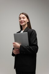 Fototapeta premium Confident young professional showcasing talent and creativity with a laptop in a studio setting