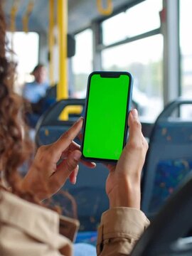 Close-up of woman&rsquo;s hands using green screen smartphone on public bus, vertical slow motion video, touchscreen interaction for app mockup, urban lifestyle and digital communication


