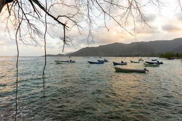 Capurgana landscape in Chocó, Colombia, with fishing boats and a beach on the Caribbean Sea at sunset.