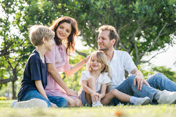 Fototapeta premium Happy family parent children having picnic outdoor activity. Enjoy happiness moment summer playing together including father mother son and daughter relaxing in the morning sunrise.