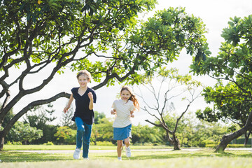 Obraz premium Brother and sister playing together at the park in the morning sunrise