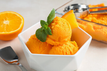 Tasty orange sorbet, fresh fruit, mint, spoon and scoop on light table, closeup