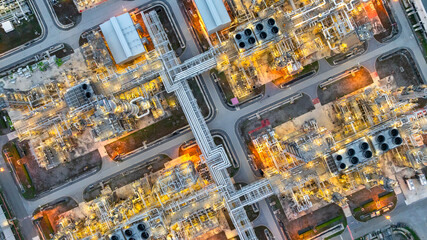 Aerial top view petrochemical plant oil refinery storage tank pipe line at night, Petroleum oil refinery industrial infrastructure oil storage tank, Oil refinery petrochemical industrial chemical.