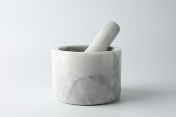 Marble mortar with pestle on white background, closeup