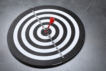 Targeting. Dart board with arrow on gray textured background