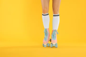 Fotobehang Woman in roller skates on orange background, closeup. Space for text © New Africa