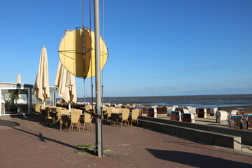 Lokal mit Terrasse an Strand der Nordsee in Cuxhaven mit gelbem Ball für Wattwanderer