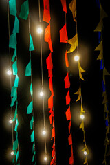 Colorful fabric streamers and string lights create a festive backdrop during nighttime celebration in Caruaru.