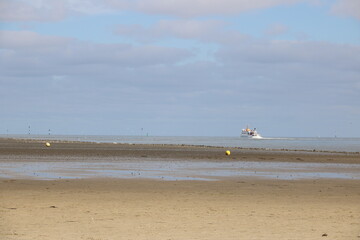 Ausflusschiff hinter dem Leitdamm in der Nordsee vor Cuxhaven mit Blick über das niedersächsische...