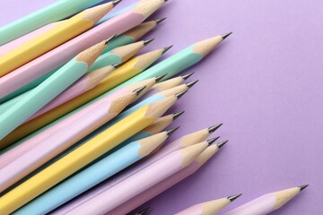 Many graphite pencils on violet background, flat lay. Space for text