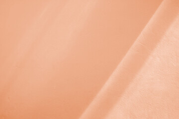 natural light and shadow drop on wall. peach fuzz color abstract textured and background.