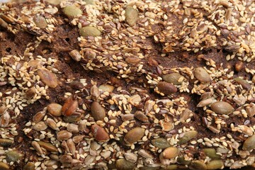 Tasty fresh bread with seeds as background, closeup
