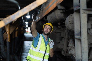Locomotive repair garage, Mechanic, Engine Mechanic. Engineer checking, repairing, maintaining locomotive engine. Railway engineer and train wheel in train garage