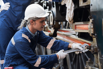 Locomotive repair garage, Mechanic, Engine Mechanic. Engineer checking, repairing, maintaining locomotive engine. Railway engineer and train wheel in train garage