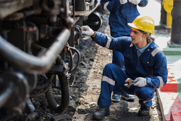 Locomotive repair garage, Mechanic, Engine Mechanic. Engineer checking, repairing, maintaining locomotive engine. Railway engineer and train wheel in train garage
