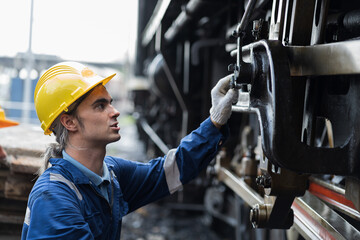 Locomotive repair garage, Mechanic, Engine Mechanic. Engineer checking, repairing, maintaining locomotive engine. Railway engineer and train wheel in train garage