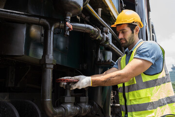 Locomotive repair garage, Mechanic, Engine Mechanic. Engineer checking, repairing, maintaining locomotive engine. Railway engineer and train wheel in train garage