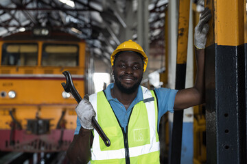 Locomotive repair garage, Mechanic, Engine Mechanic. Black people. African American engineer checking, repairing, maintaining locomotive engine. Railway engineer and train wheel in train garage