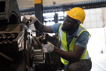 Locomotive repair garage, Mechanic, Engine Mechanic. Black people. African American engineer checking, repairing, maintaining locomotive engine. Railway engineer and train wheel in train garage