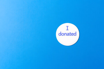 Proud donor: Button on blue background. Sharing and caring in the community. Give back, make a difference, support a cause. Donate today!