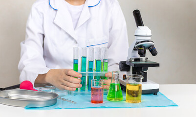 Laboratory research test tubes reagents and microscope. Selective focus.