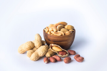 Peanuts  in  wooden bowls a collection of whole peanuts in their shells and a few without shells,healthy snacking concept with peanuts rich in protein and fats, isolated on white background.