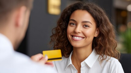 Young Woman Smiling While Receiving Bank Card from Male Banker in Modern Indoor Setting