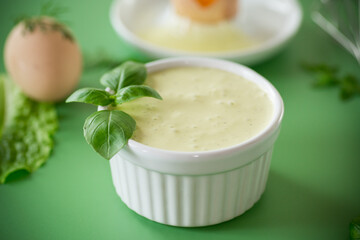 Top view of homemade mayonnaise with green herbs and eggs